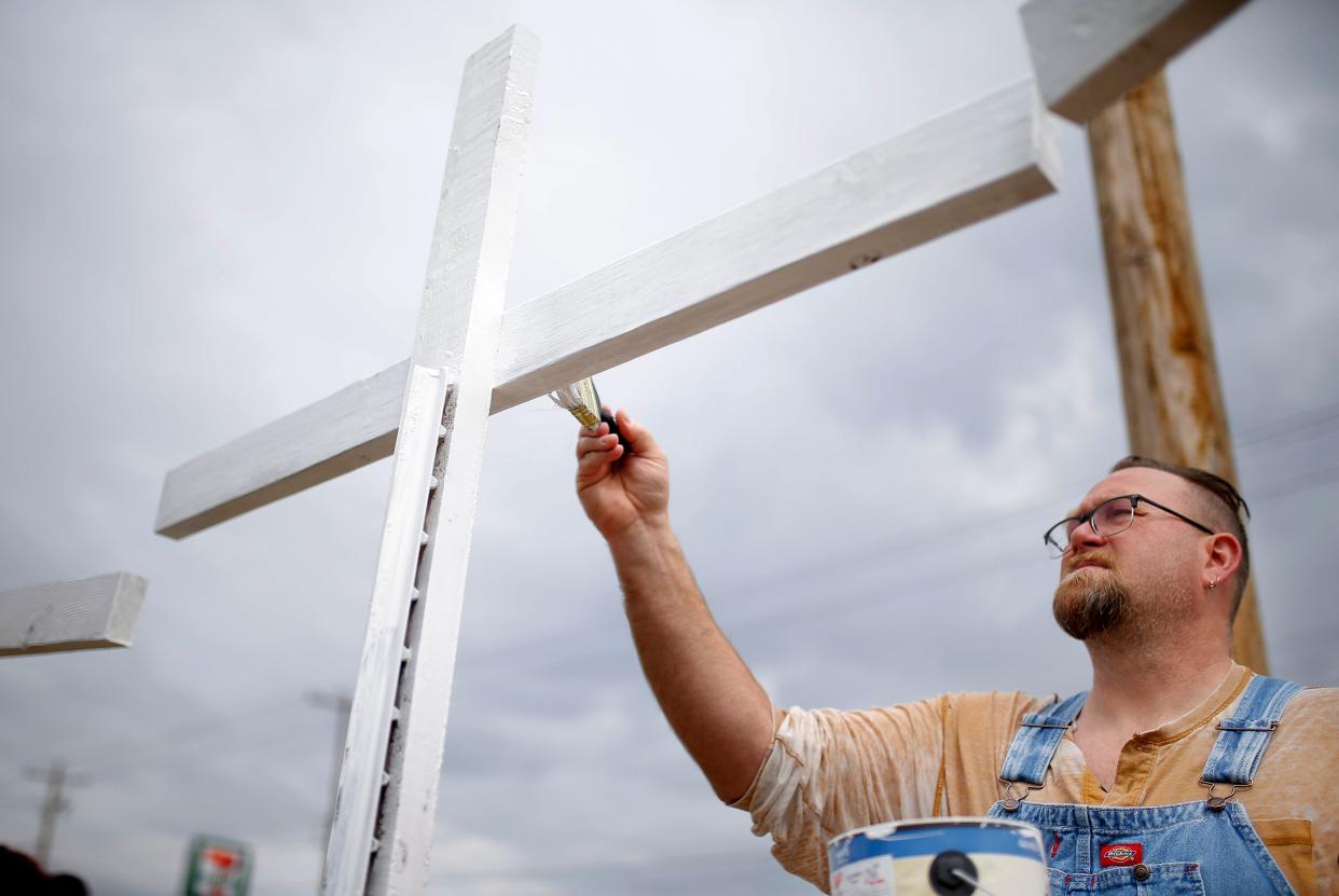 The Rev. Bo Ireland paints crosses Wednesday at the Clark United Methodist Church in Oklahoma City. The crosses are memorials for those executed by the state of Oklahoma.