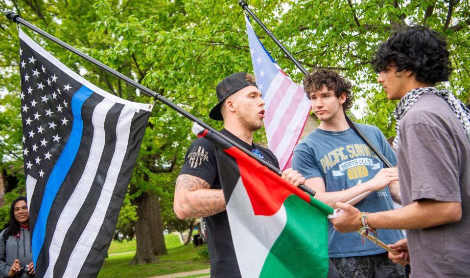 Demonstrators with flags talk calmly with demonstrators with flags of Palestine during the pro-Palestine demonstration at Dunn Meadow on Friday, April 26, 2024.