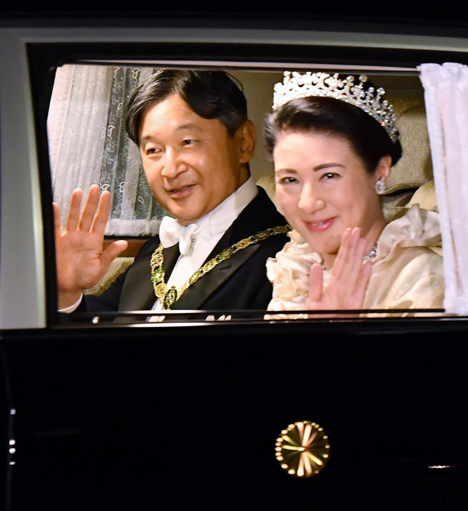 Japan's Emperor Naruhito, left, and Empress Masako, right, wave, as they depart for the Imperial Palace for the court banquet, in Tokyo, Tuesday, Oct. 22, 2019. Japan's Naruhito proclaimed himself Emperor during an enthronement ceremony at the Imperial Palace, declaring himself the country's 126th monarch.(Ren Onuma/Kyodo News via AP)