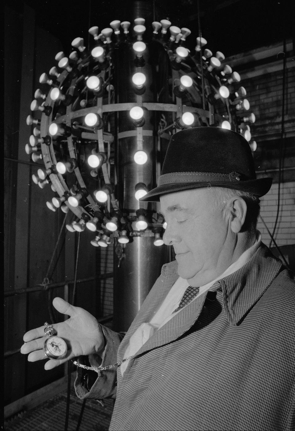 man in hat checks watch before new year's ball drop times square 