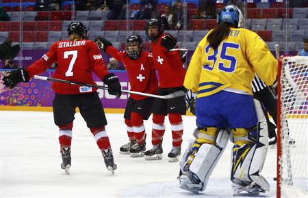 Switzerland's Jessica Lutz (R) celebrates her goal against Sweden's goalie Valentina Wallner (L) with teammates Sara Benz (13) and Lara Stalder (7) during the third period of their women's ice hockey bronze medal game at the Sochi 2014 Winter Olympic Games February 20, 2014. REUTERS/Mark Blinch