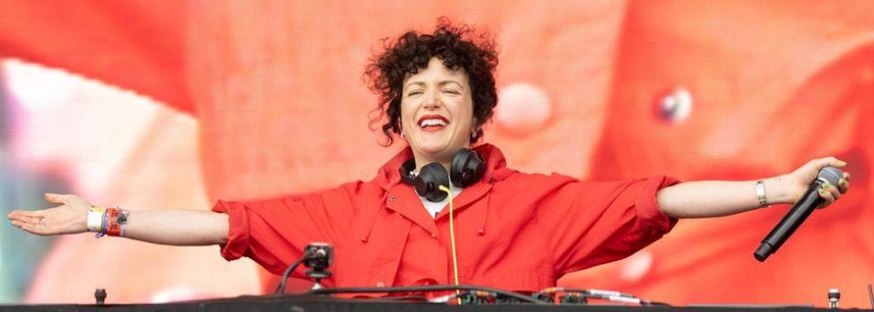 Annie Mac smiling and with her arns outstretched on stage
