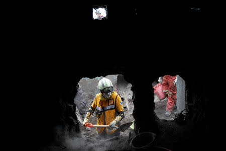 Rescue workers search for missing families at the area affected by the Fuego volcano at San Miguel Los Lotes in Escuintla, Guatemala June 15, 2018. REUTERS/Carlos Jasso