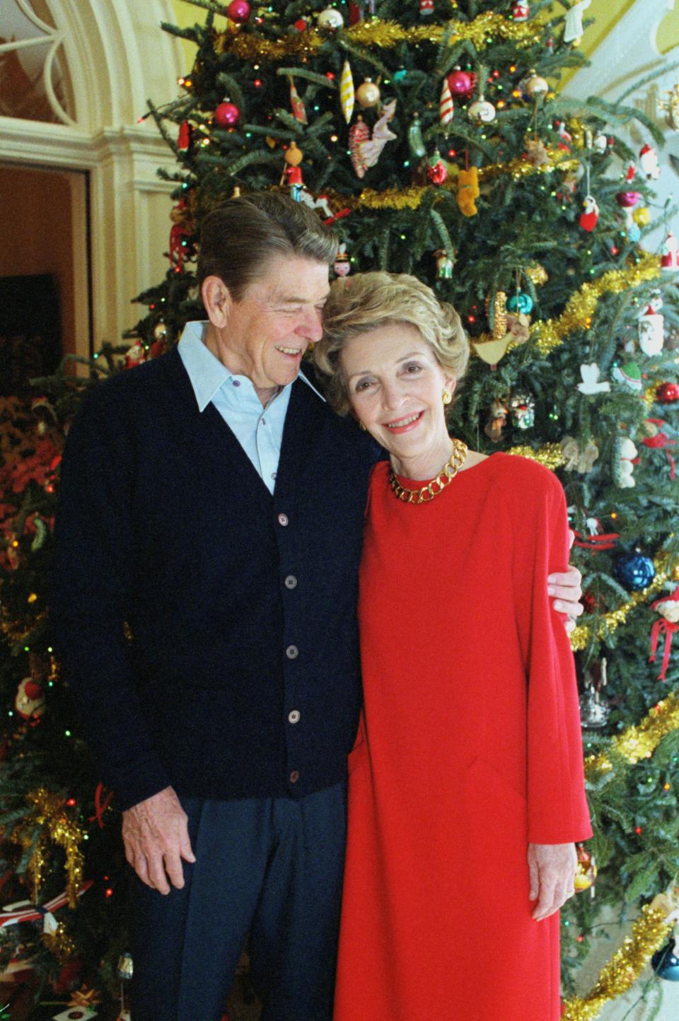 Ronald and Nancy Reagan pose in front of a Christmas tree in 1985.