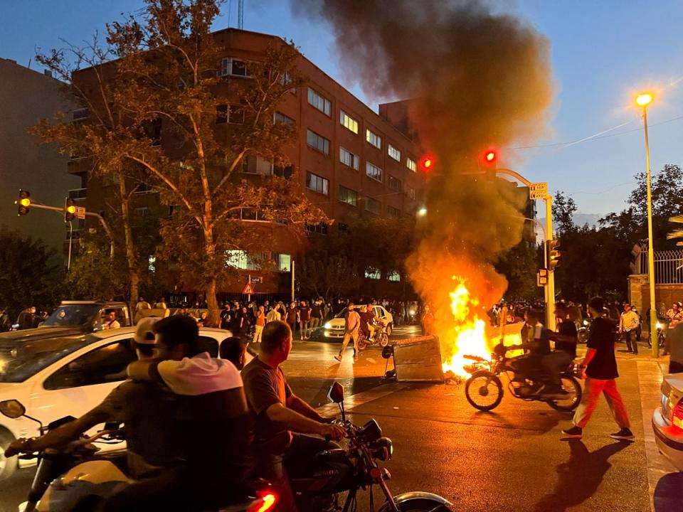 A police motorcycle burns during a protest over the death of Mahsa Amini (via REUTERS)