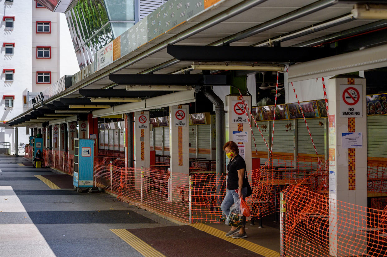 A woman walks in the closed Food Centre linked to  a large new cluster of new covid-19 cases in the Bukit Merah public housing district of Singapore on 17 June, 2021. The new cases across Food Centres in adjacent public housing districts have now cast doubt on whether Singapore will be able to relax pandemic restrictions next week as planned. (Photo by Joseph Nair/NurPhoto via Getty Images)