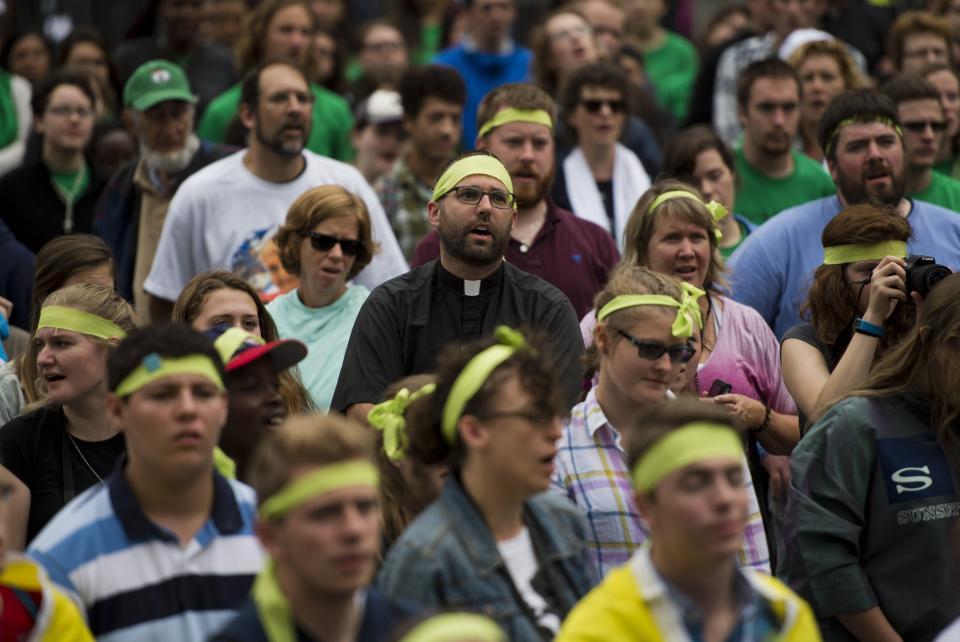 Catholic devotees sing as they watch Pope Francis' Mass.