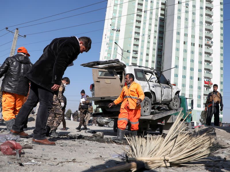 Afghan security officials inspect the site of a blast in Kabul, Afghanistan