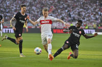 Stuttgart's Chris Fuehrich, center, and Frankfurt's Niels Nkounkou, right, challenge for the ball during the German Bundesliga soccer match between VfB Stuttgart and Eintracht Frankfurt in Stuttgart, Germany, Saturday, April 13, 2024. (Jan-Philipp Strobel/dpa via AP)