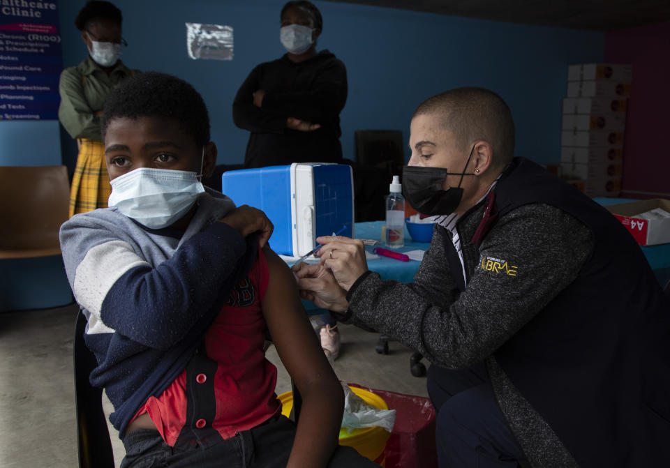 FILE — A boy gets vaccinated against COVID-19 at a site near Johannesburg, Dec. 8, 2021. Health experts still don't know if omicron is causing milder COVID-19 but some more hints are emerging with doctors in South Africa saying their patients aren't getting as sick with omicron, compared to the delta variant. (AP Photo/Denis Farrell;File)