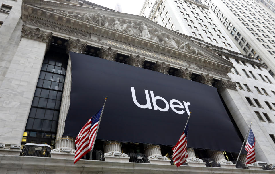 The Uber banner hangs on the facade of the New York Stock Exchange, Friday, May 10, 2019. The world's largest ride-hailing service reached a major milestone Thursday when Uber priced its long-awaited initial public offering at $45 price per share to set the stage for its stock to begin trading Friday morning. (AP Photo/Richard Drew)