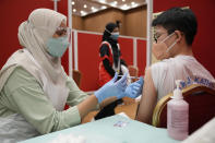 A secondary school student, receives a dose of the Pfizer vaccine against the coronavirus disease (COVID-19) at a vaccine center in Shah Alam, Malaysia, Monday, Sept. 20, 2021. (AP Photo/Vincent Thian)