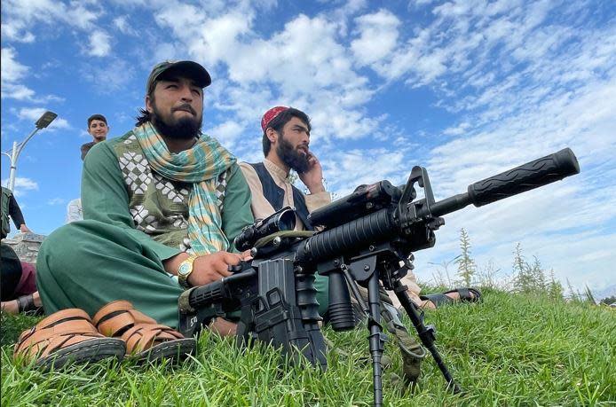 Taliban militants sit in a Kabul park in August 2022. / Credit: CBS News