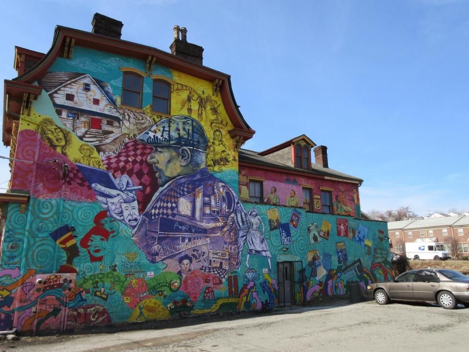 This Feb. 17, 2017 photo shows a colorful mural in the Hill District of Pittsburgh honoring playwright August Wilson and his work. The Hill District offers a rich map of places and stories connected to Wilson's plays, nine of which are set in Pittsburgh. Artist Kyle Holbrook created the mural with children from a local arts program. (AP Photo/Beth J. Harpaz)