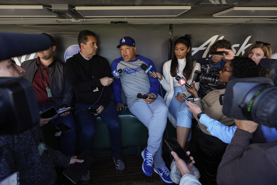 Los Angeles Dodgers manager Dave Roberts, center, speaks to reporters in the dugout before the team's baseball game against the San Francisco Giants, Tuesday, May 14, 2024, in San Francisco. (AP Photo/Godofredo A. Vásquez)