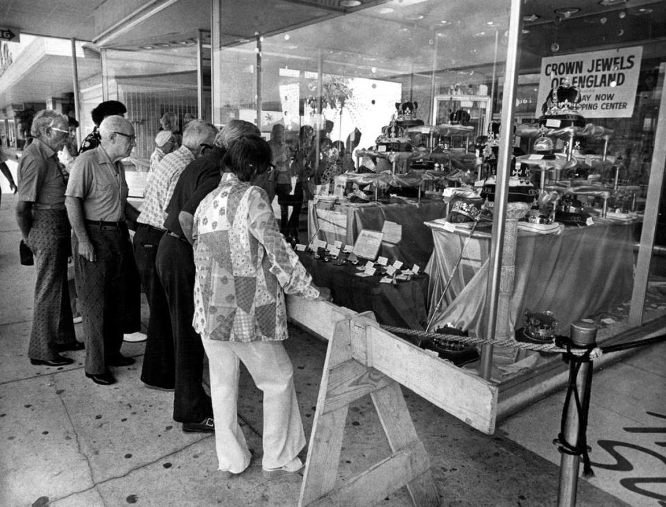 Undated file photo predating the 1980s shows a small group of people looking into a storefront window at The Mall at 163rd Street shopping center at a display of the “Crown Jewels of England.”