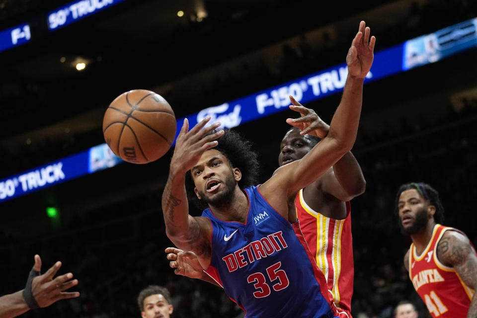 Detroit Pistons forward Marvin Bagley III (35) and Atlanta Hawks center Clint Capela (15) battle battle for a loose ball during the first half of an NBA basketball game Monday, Dec. 18, 2023, in Atlanta. (AP Photo/John Bazemore)