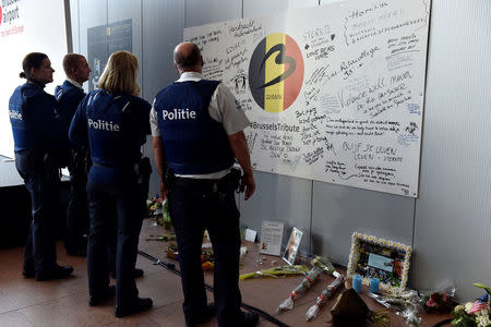 Police officers stand in front of a tribute to the victims in the departure hall after a ceremony at Brussels Airport as it reopens 40 days after deadly attacks in Zaventem, Belgium, May 1, 2016. REUTERS/Eric Vidal