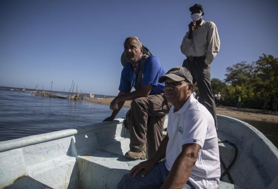 Agronomist and horticulturalist Frederick Payton, right, and marine biologist Jean Wiener, left centre, cross the Massacre River in order to attend a rare face-to-face meeting between fishermen from Haiti and the Dominican Republic, in Fort-Liberte (AP)