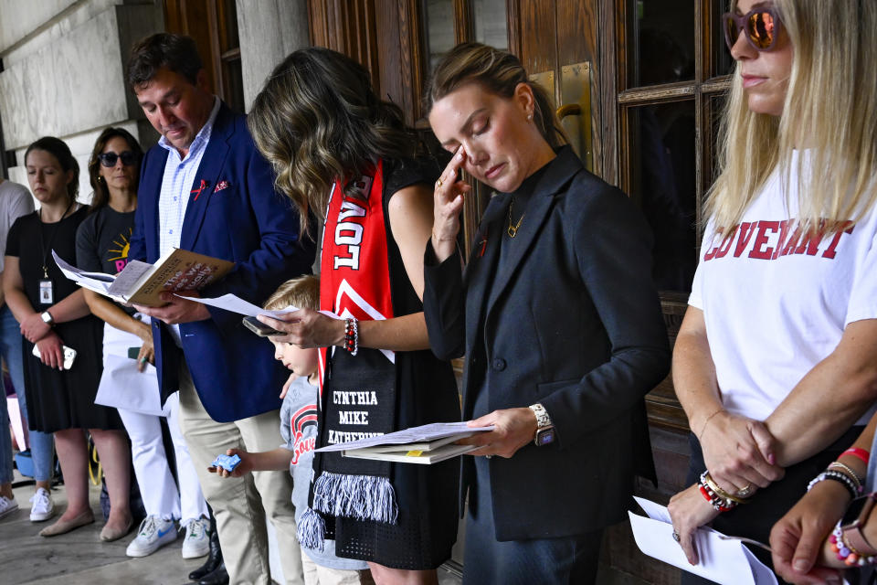 FILE - Covenant School mother, Melissa Alexander, wipes her eye as she engages in a prayer service leading up to a special session of the state legislature before a news conference at the state capitol, July 20, 2023, in Nashville, Tenn. Nearly a year after a shooting at a Christian elementary school in Nashville that left three adults and three children dead, the students and their families have formed tight bonds out of their shared suffering. (AP Photo/John Amis, file)