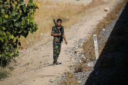 A soldier watches a train traveling through the outskirts of Damascus towards recently opened international fair in Damascus, Syria, September 15, 2018. REUTERS/Marko Djurica