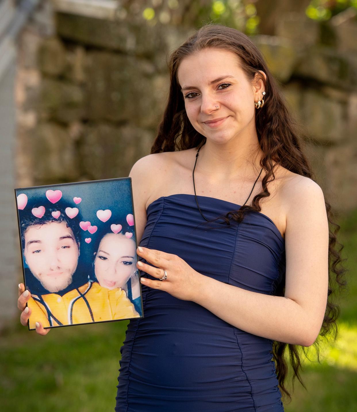 Taralina Mitchell of Whitinsville holds a photograph of her and boyfriend, David LeBoeuf, Monday.