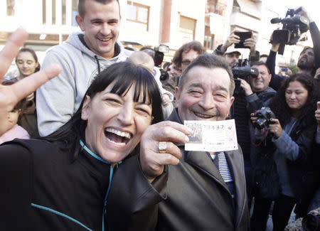 Juan Lopez holds his lottery ticket with the winning number of Spain's Christmas Lottery "El Gordo", together with his daughter Pilar in La Eliana near Valencia December 22, 2014. REUTERS/Heino Kalis