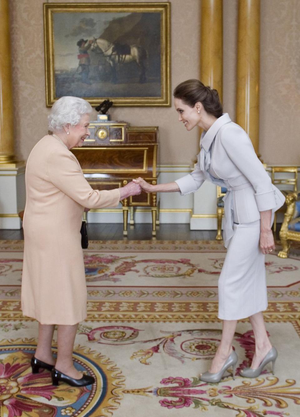 <p>Angelina Jolie wore a pale collared suit to meet the Queen when she received an honorary damehood for her work in UK foreign policies and in the campaign to stop war-zone sexual violence.</p>