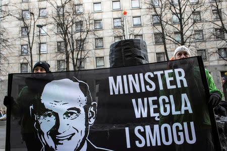 Greenpeace activists demonstrate on the street following the decision of the Court of Justice of the European Union (CJEU), after they handed a big, carbon cake to Poland's Energy Mister Krzysztof Tchorzewski as a symbol of 'protecting Polish smog', in Warsaw, Poland February 22, 2018. The banner reads: 'Minister of carbon and smog'. Agencja Gazeta/Dawid Zuchowicz via REUTERS