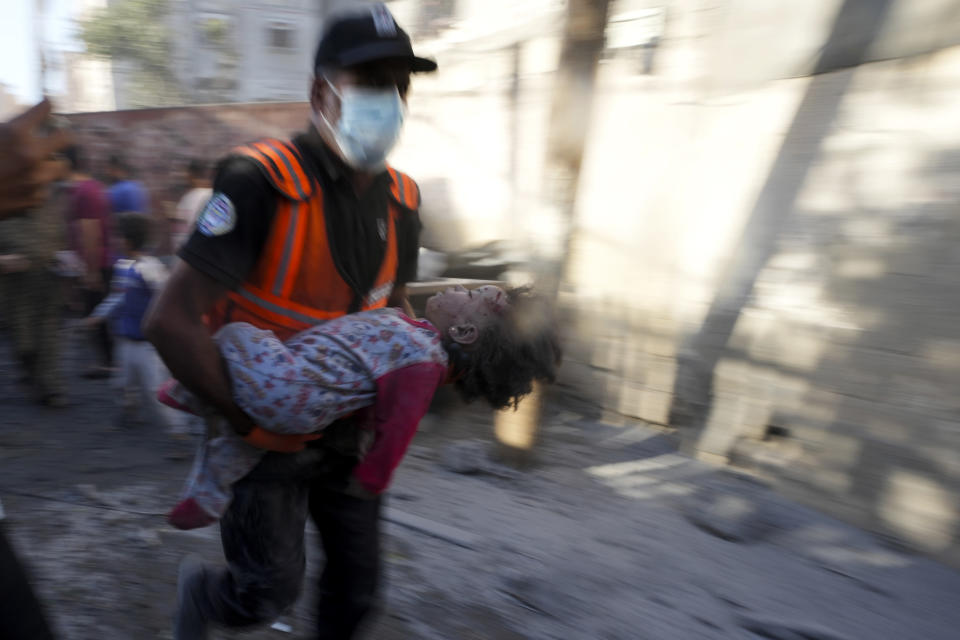 Palestinians evacuate survivors after Israeli airstrikes on buildings in Deir al Balah, Gaza Strip, Tuesday, Nov. 7, 2023. (AP Photo/Adel Hana)