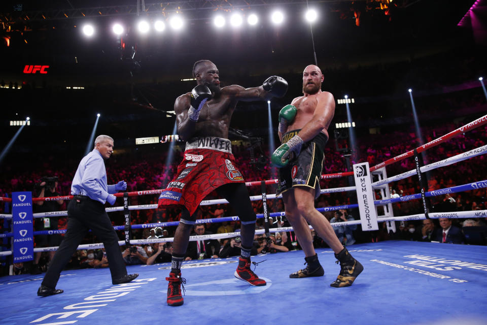 Deontay Wilder swings at Tyson Fury, of England, in a heavyweight championship boxing match Saturday, Oct. 9, 2021, in Las Vegas. (AP Photo/Chase Stevens)