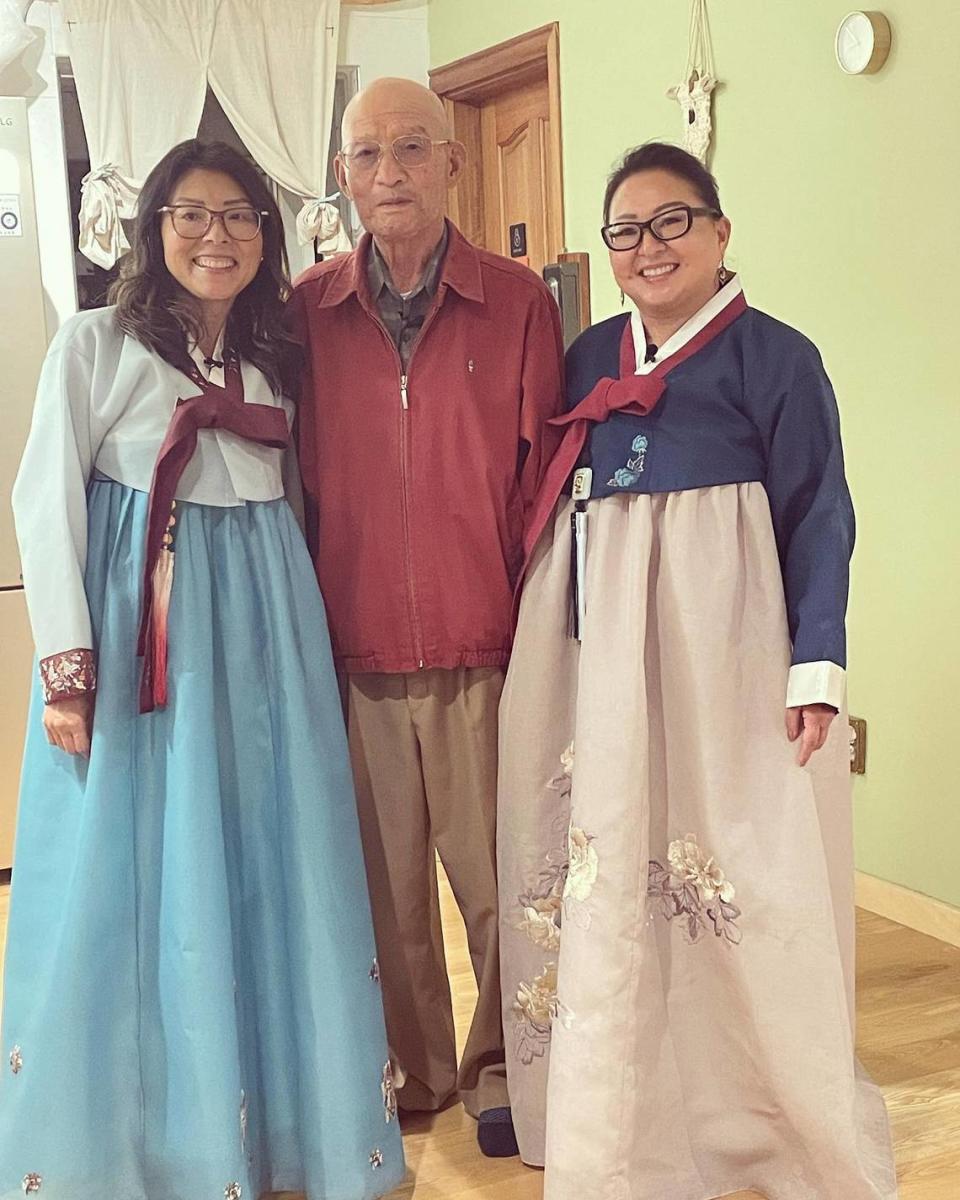 Dee, left, and Becca pose with their birth father Mr. Park while wearing hanboks he had made for them.