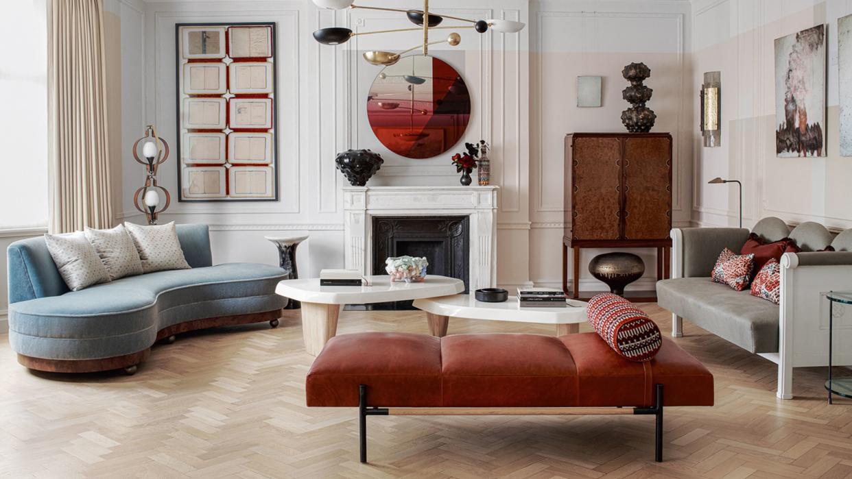  Traditional eclectic living room with daybed, blue sofa, fireplace, pendant light and parquet floors. 