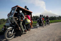 Residents wear face masks as they board a motorised tricycle towards an evacuation center, as the Mayon volcano spews ash in Guniobatan, Albay Province, Philippines January 23, 2018. REUTERS/Stringer