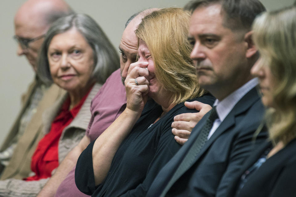 Kathy Olsen, wife of Robert "Chip" Olsen, is consoled as the verdict for her husband's trial is read in front of DeKalb County Superior Court Judge LaTisha Dear Jackson at the DeKalb County Courthouse in Decatur, Ga., Monday, Oct. 14, 2019. The former Georgia police officer who fatally shot an unarmed, naked man was found not guilty of murder on Monday, but was convicted of aggravated assault and other charges that could potentially send him to prison for more than 30 years. (Alyssa Pointer/Atlanta Journal-Constitution via AP, Pool)