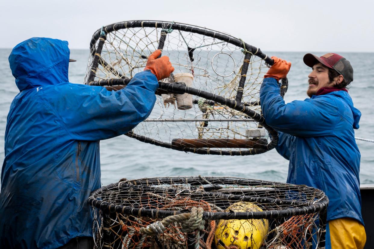 Lyle Ashouwak (left) and Anthony Abell (right) drop crab pots off the Fishing Vessel Insatiable. As ocean temperatures rise, fishermen everywhere must adapt to harvesting different species. Garrett Kavanaugh, captain of the Fishing Vessel Insatiable out of the port of Kodiak Island, has made significant investments in equipment, fuel, and labor, betting on Dungeness crabs as the future of his Alaskan fishing business.