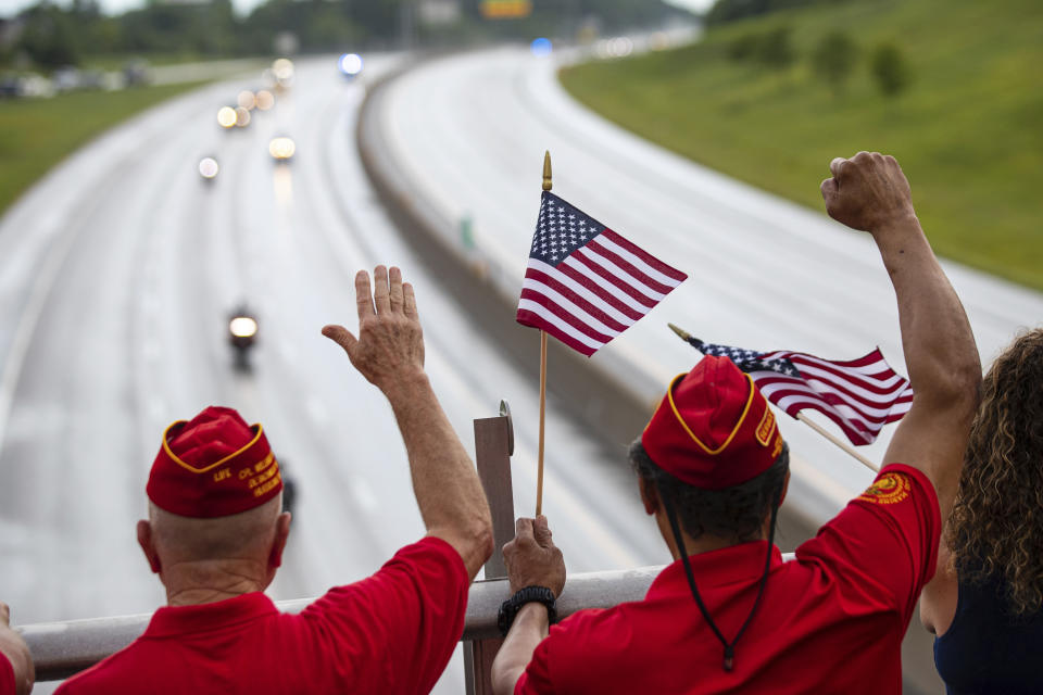 Marine Corps League veterans wave as the funeral procession for Medal of Honor recipient Hershel "Woody" Williams moves along Interstate 64 on Saturday, July 2, 2022, in Teays Valley, W.Va. (Sholten Singer/The Herald-Dispatch via AP)