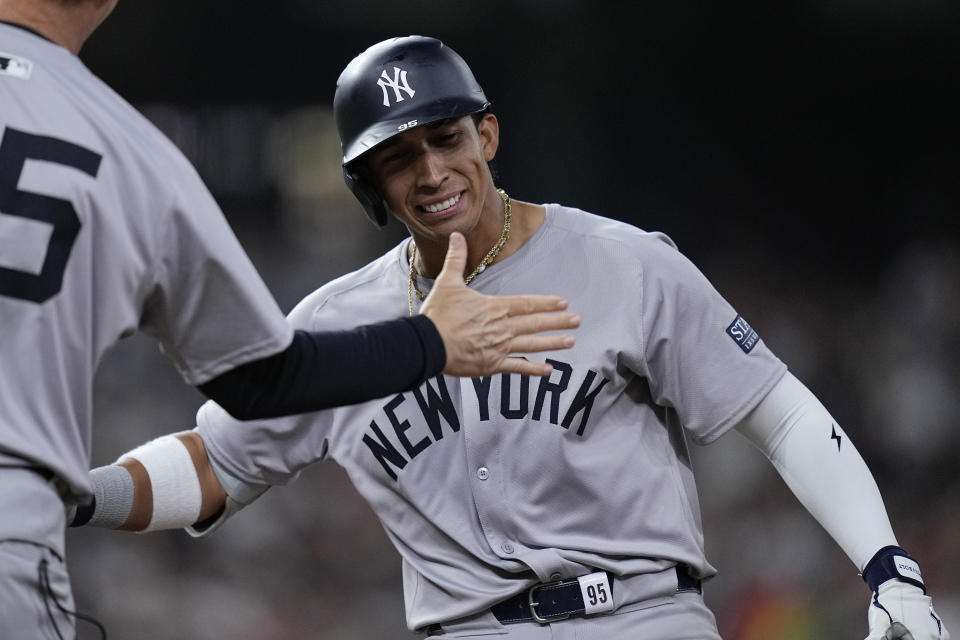 New York Yankees' Oswaldo Cabrera, right, celebrates with first base coach Travis Chapman after hitting a two-run single during the eighth inning of a baseball game against the Houston Astros, Friday, March 29, 2024, in Houston. (AP Photo/Kevin M. Cox)