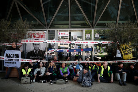 Environmental activists block the entrance to the headquarters of French oil giant Total during a "civil disobedience action" to urge world leaders to act against climate change, in La Defense near Paris, France, April 19, 2019. REUTERS/Benoit Tessier