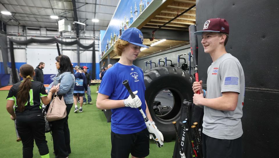 From left, Gavin Gillpatrick and Jayden Murphy looks over new baseball bats before trying them out during opening day at East Coast Eagles' new training facility, 738 North Bedford St., East Bridgewater on Tuesday, Nov. 15, 2022.