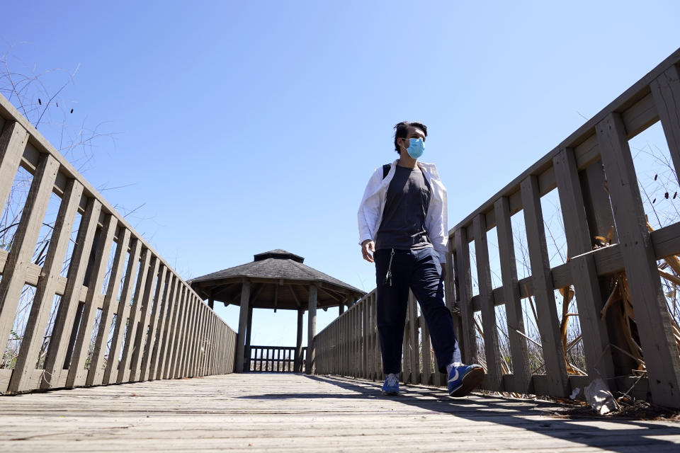 Ricardo Ramirez walks along a walkway after an interview Thursday, April 23, 2020, near his home in Houston. Ramirez is observing Ramadan for the first time as a Muslim after converting to Islam last year. Ramadan is typically a time of communal meals and praying in congregation. This year, the month comes as the coronavirus pandemic has disrupted Islamic worship and spurred mosque closures to the public. (AP Photo/David J. Phillip)