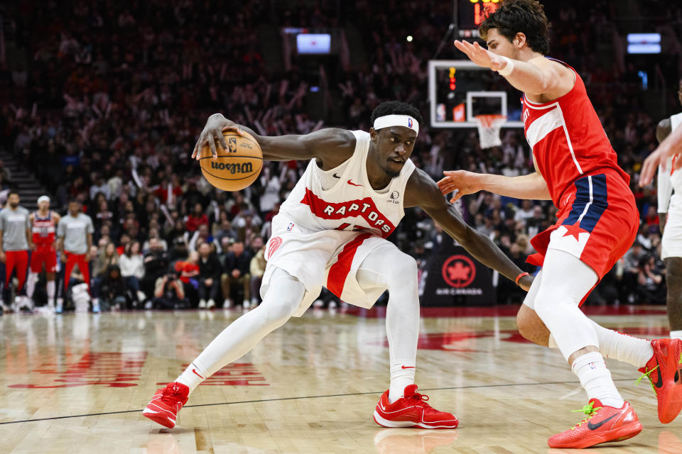 Toronto Raptors forward Pascal Siakam protects the ball from Washington Wizards forward Deni Avdija during the second half of a NBA basketball game in Toronto on Monday, Nov. 13, 2023. (Christopher Katsarov/The Canadian Press via AP)