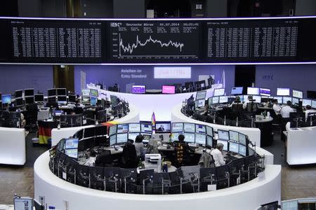 Traders are pictured at their desks in front of the DAX board at the Frankfurt stock exchange, July 1, 2014. REUTERS/Remote/Thomas Peter