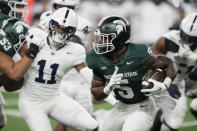 Michigan State running back Nathan Carter (5) rushes during the first half of an NCAA college football game against Penn State, Friday, Nov. 24, 2023, in Detroit. (AP Photo/Carlos Osorio)