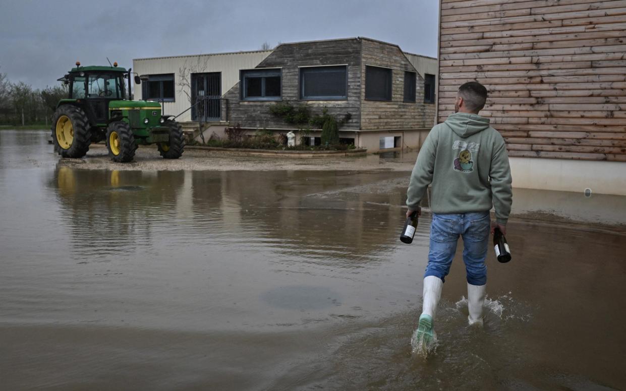 A winegrower at the Domaine du Chardonnay walks through the flooded estate during a period of heavy rain throughout Burgundy last month