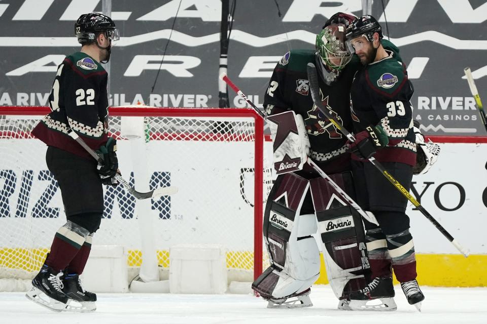 Arizona Coyotes defenseman Alex Goligoski, right, congratulates Coyotes goaltender Antti Raanta, center, after a win against the San Jose Sharks as teammate Johan Larsson, left, looks on after an NHL hockey game Saturday, Jan. 16, 2021, in Glendale, Ariz. The Coyotes defeated the Sharks 5-3. (AP Photo/Ross D. Franklin)