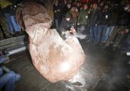 A man holds a sledgehammer as he smashes a statue of Soviet state founder Vladimir Lenin, which was toppled by protesters during a rally organized by supporters of EU integration in Kiev, December 8, 2013. Crowds toppled a statue of Soviet state founder Vladimir Lenin in the Ukrainian capital and attacked it with hammers on Sunday in the latest mass protests against President Viktor Yanukovich and his plans for closer ties with Russia. REUTERS/Stoyan Nenov (UKRAINE - Tags: POLITICS CIVIL UNREST)