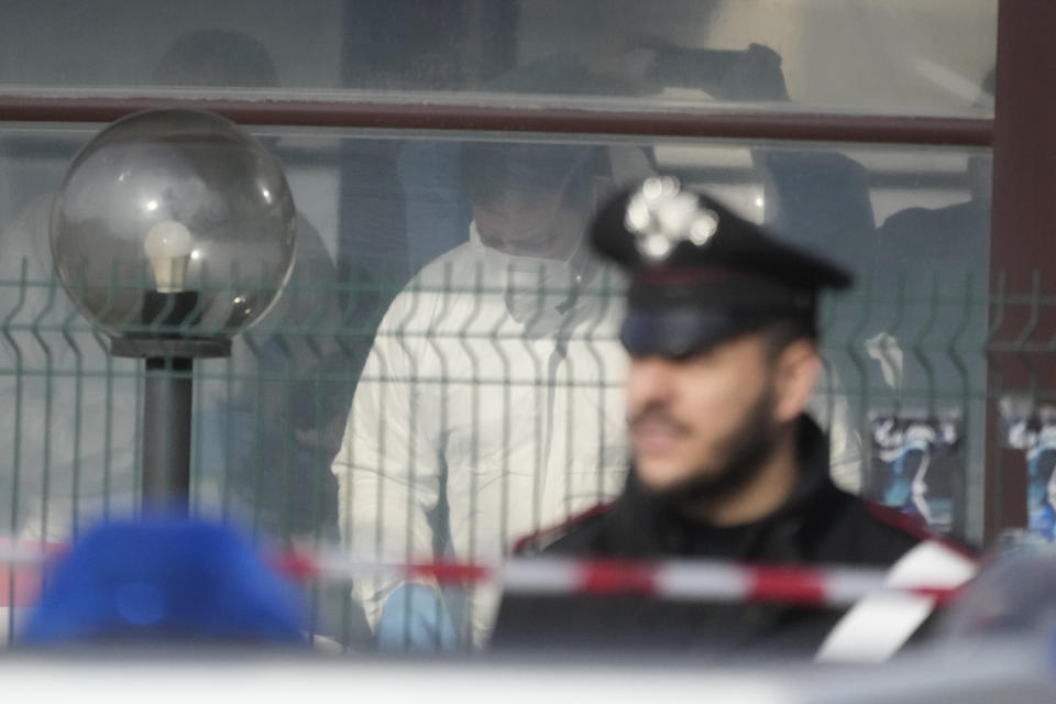 Forensic police officers inspect a bar where three people died after a man entered and shot in Rome, Sunday, Dec. 11, 2022. (AP Photo/Gregorio Borgia)