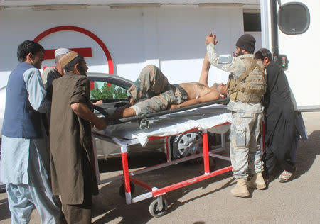 Afghan security forces members carry an injured policeman to a hospital after a blast in Helmand, Afghanistan October 17, 2018. REUTERS/Stringer