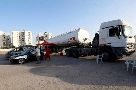 People fill their cars with fuel from state fuel distribution company, Brega, in Tripoli